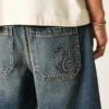 Baggy denimshorts med slangegrafikk
