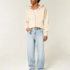 Broderte, lysevaskede skaterbaggyjeans
