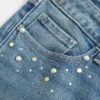 Lavt sittende bootcut-jeans med medium vask og nitter