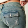 Lavt sittende bootcut-jeans med sommerfuglbroderi i medium vask