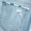 Lavt sittende, lettvasket bootcut-jeans med broderi og rift
