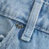 Lavt sittende, lysvasket baggy jeans med nitter og sløyfer