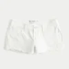 Lavt sittende mini-shorts i hvit denim med slitt look