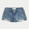 Lavt sittende mini-shorts i mediumvasket denim med slitt look