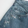 Lavt sittende, mørkvasket baggy jeans med blomsterbroderi