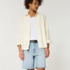 Løse denimshorts over kneet med slitt look