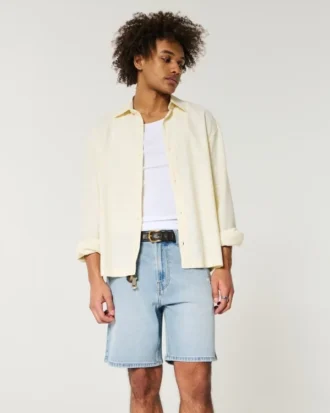 Løse denimshorts over kneet med slitt look