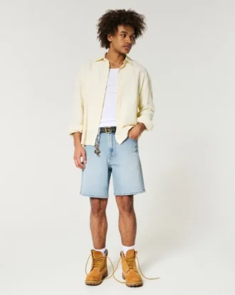 Løse denimshorts over kneet med slitt look
