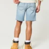 Løse denimshorts over kneet med slitt look