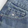 Ultra lav midje, medium vasket, blomsterbrodert denim minishorts