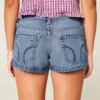 Ultra lav midje, slitt mediumvasket denim minishorts