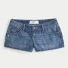 Ultra lav midje, slitt mediumvasket denim minishorts