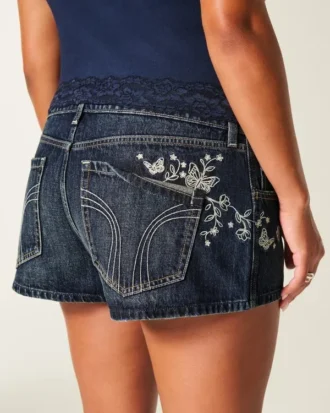 Ultra lavt sittende mørkvaskede minishorts i denim med brodert sommerfugl
