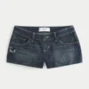 Ultra lavt sittende mørkvaskede minishorts i denim med brodert sommerfugl