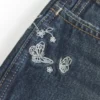 Ultra lavt sittende mørkvaskede minishorts i denim med brodert sommerfugl